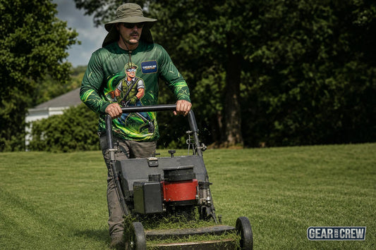 Landscaper mowing in a long sleeve all-over print sun shirt and wide brim boonie hat in midday sun